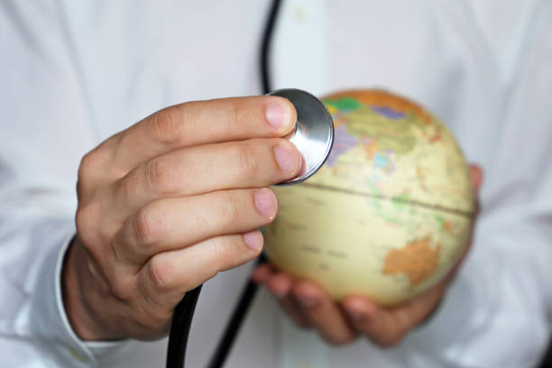 istock Doctor with stethoscope and globe in his hand 1147256256
