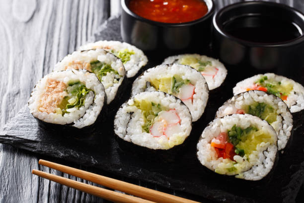 istock Futomaki rolls with various fillings are served with sauces close-up on a slate board. horizontal 1147258956