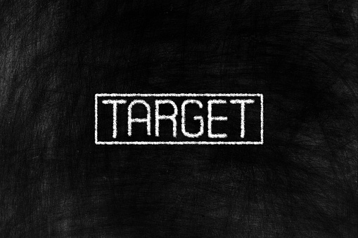 Target in Chalk Writing on Old Grunge Chalkboard Background, Suitable for Education and Business Concept.