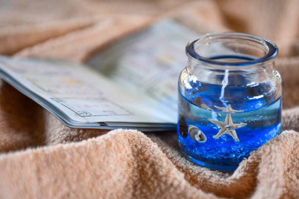 istock Beach themed candle and open passport with stamps 1147260554