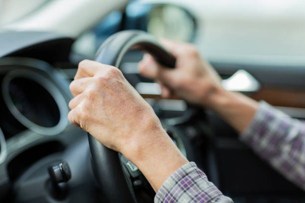 anciano conduciendo un coche - lanzar fotografías e imágenes de stock