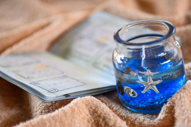 istock Beach themed candle and open passport with stamps 1147261304