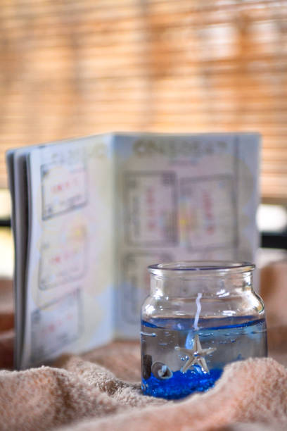 istock Beach themed candle and open passport with stamps 1147261311