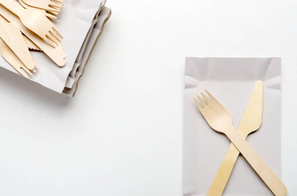 istock Wooden single use kitchenware and paper plate on white background closeup. Top view 1147262546
