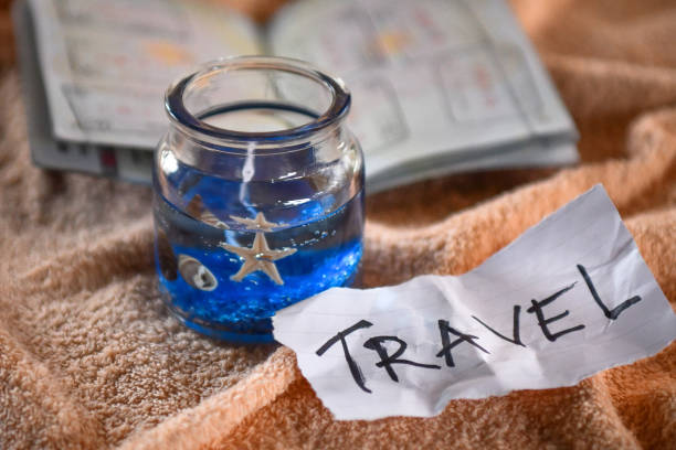 istock Beach themed candle, travel note and open passport with stamps 1147262585