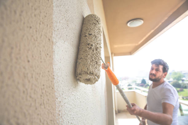 istock Young man painting a wall renkli with a roller 1147264675