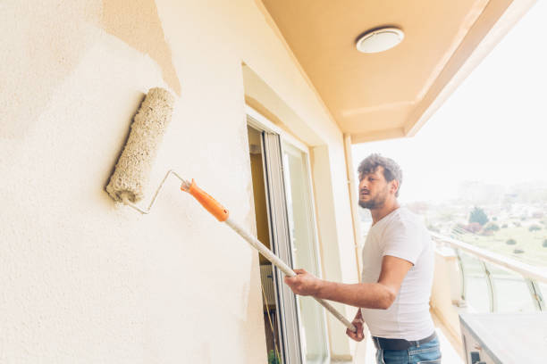 istock Young man painting a wall renkli with a roller 1147264676