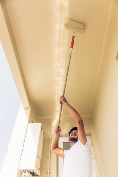 istock Young man painting a wall renkli with a roller 1147264718
