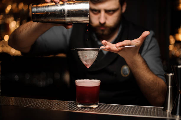 istock Bartender makes alcohol drink with a shaker and sieve 1147264761