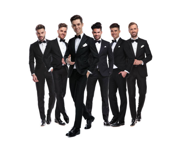 istock man in tuxedo pointing hand while walking besides his team 1147266266