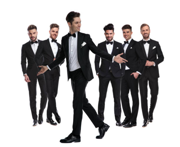 istock smiling  man in tuxedo walks and welcomes while looking back 1147266359