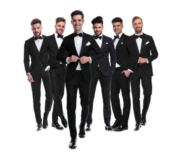 istock man buttoning his tuxedo while walking in front of  team 1147266444