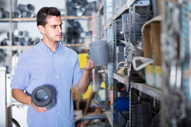 istock Shop assistant is checking plastic trumpet for plumbing works 1147266529