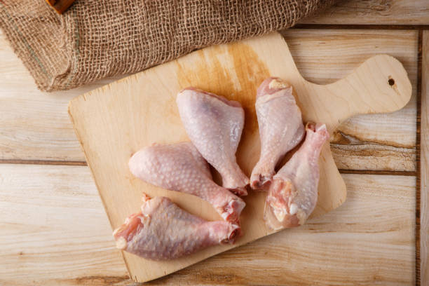 istock raw chicken legs on a wooden tray 1147268305