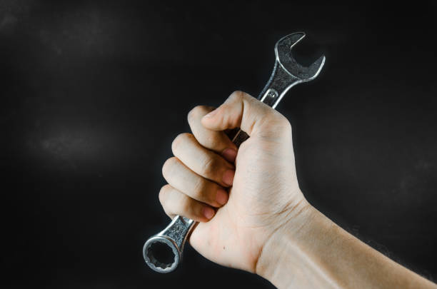 istock hand hold wrench on black background 1147276670