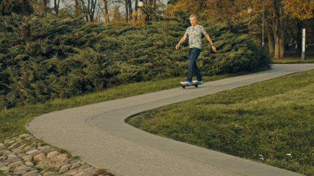 istock Fit senior riding skateboard in park. Retirement activities 1147276872