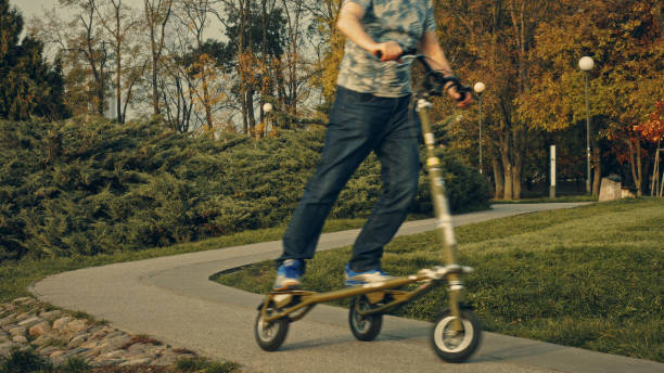 istock Fit senior riding slider scooter in park. Retirement activities 1147276888