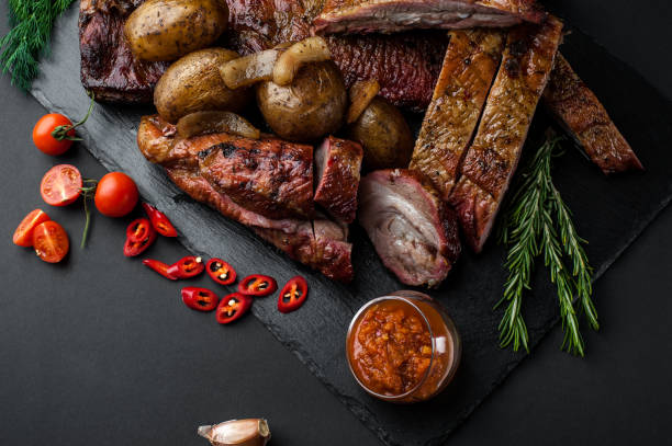 istock Smoked and dried meat on a black background 1147277053