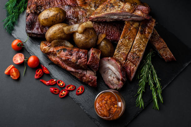 istock Smoked and dried meat on a black background 1147277093