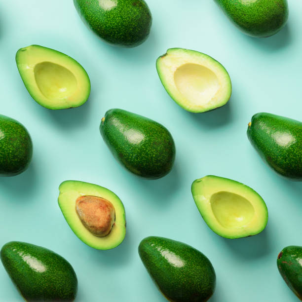istock Avocado pattern on blue background. Top view. Banner. Pop art design, creative summer food concept. Green avocadoes, minimal flat lay style. Square crop 1147277383