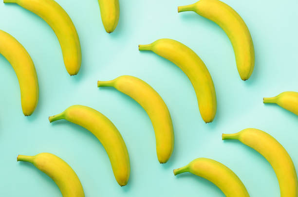 istock Colorful fruit pattern. Bananas over blue background. Top view. Pop art design, creative summer concept. Minimal flat lay style. 1147277474