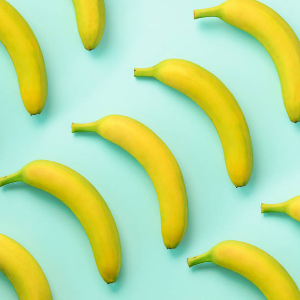 istock Colorful fruit pattern. Bananas over blue background. Square crop. Top view. Pop art design, creative summer concept. Minimal flat lay style. 1147277478