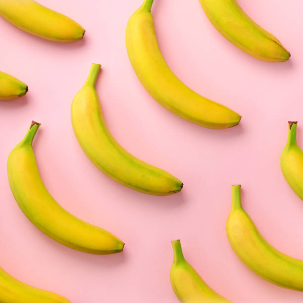 istock Colorful fruit pattern. Bananas over pink background. Square crop. Top view. Pop art design, creative summer concept. Minimal flat lay style. 1147277502