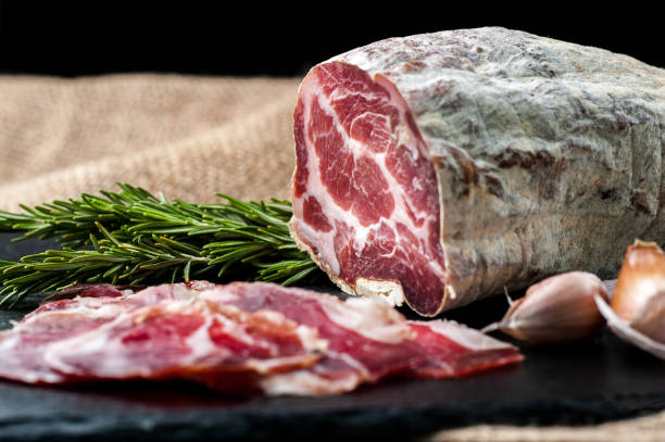 istock Smoked and dried meat on a black background 1147277520