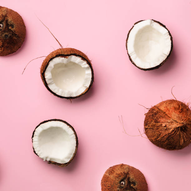 istock Pattern with ripe coconuts on pink background. Top View. Copy Space. Square crop. Pop art design, creative summer concept. Half of coconut in minimal flat lay style. 1147277527