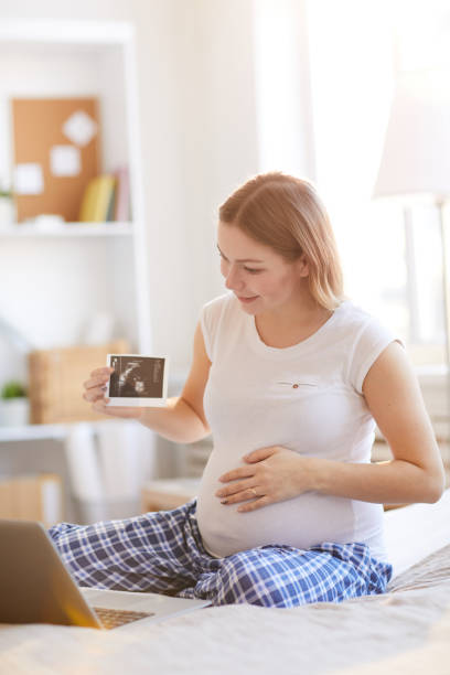 schwangere frau ruft per video-chat - human pregnancy telephone ultrasound family stock-fotos und bilder