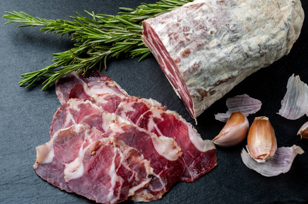 istock Smoked and dried meat on a black background 1147277628