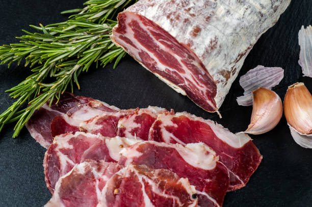 istock Smoked and dried meat on a black background 1147277658