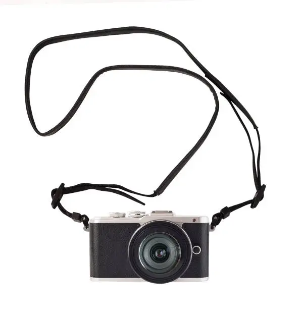 Photo of Photographic mirrorless system camera with curved strap.