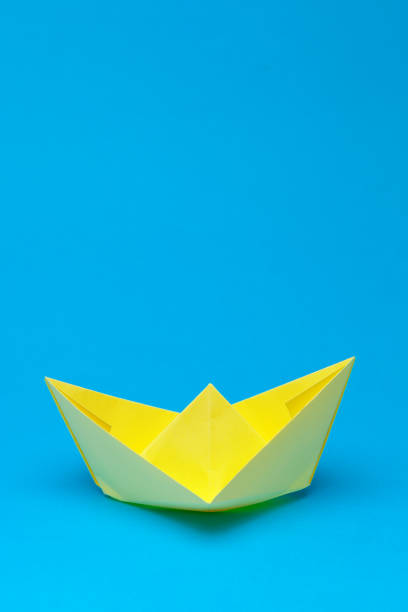 istock Origami paper boat on blue background 1147281445