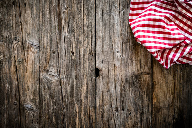 istock Empty rustic wooden table with gingham tablecloth at the top right border. Copy space available. 1147281839
