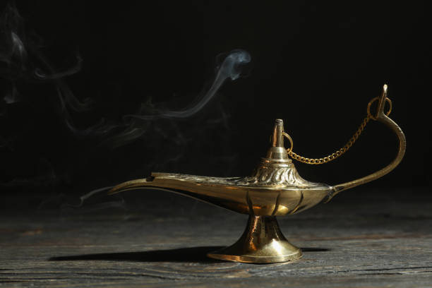 istock Magic Aladdin Lamp on wooden table against dark background 1147281956