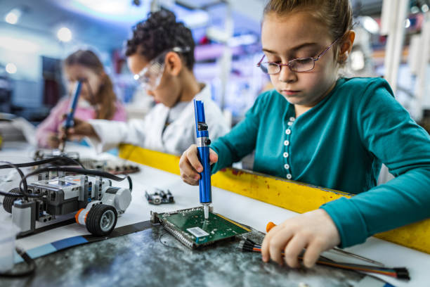 istock Small girl working on motherboard in laboratory. 1147281998