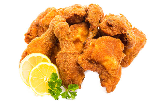 istock fried chicken pieces with lemon and parsley isolated on white background 1147282646