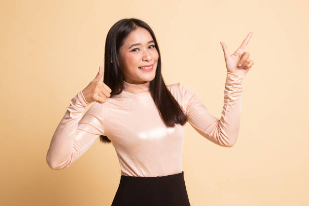 istock Young Asian woman point and thumbs up. 1147282966