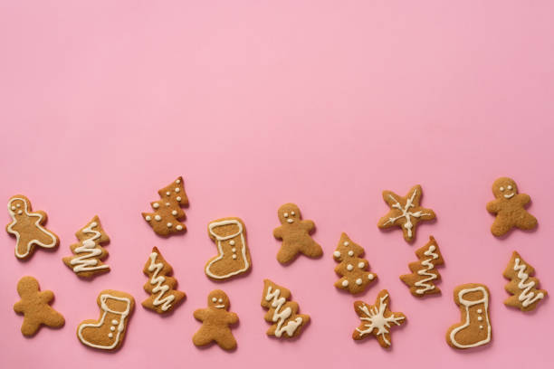 istock Christmas handmade cookies on pink background with copy space. Pattern of gingerbread men, snowflake, star, fir-tree, boot shapes. New year concept 1147284721