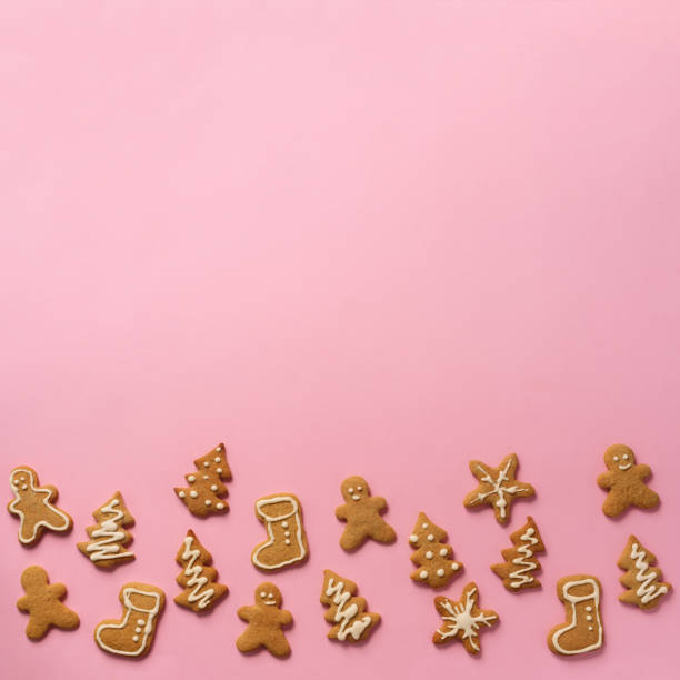 istock Homemade christmas cookies on pink background with copy space. Square crop. Pattern of gingerbread men, snowflake, star, fir-tree, boot shapes. New year concept 1147284731