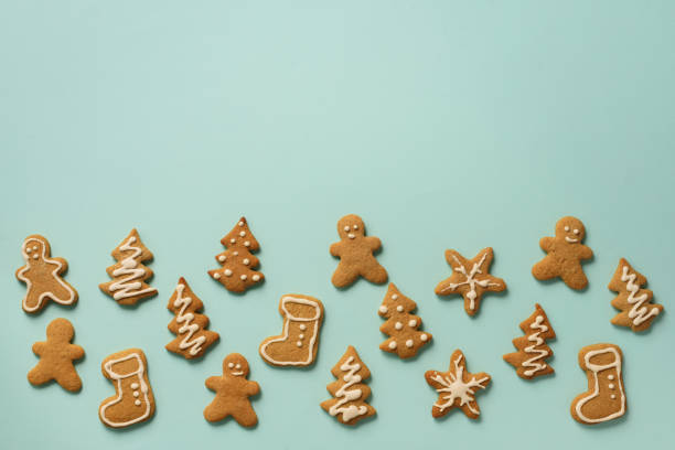 istock Christmas handmade cookies on blue background with copy space. Pattern of gingerbread men, snowflake, star, fir-tree, boot shapes. New year concept 1147284733
