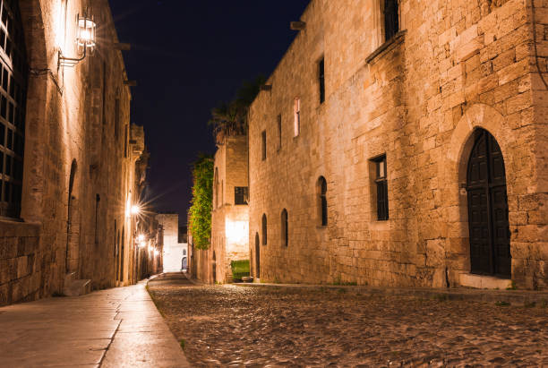 nachtfoto der alten straße der ritter in rhodos stadt auf rhodos insel, dodekanes, griechenland. steinmauern und helle nachtlichter. berühmtes touristenziel in südeuropa - sea aegean sea night illuminated stock-fotos und bilder