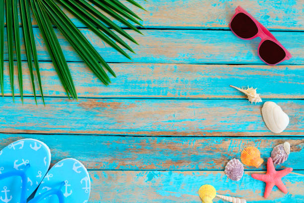 istock Summer background with sunglasses, shells, starfish and slipper on wood background. 1147285926