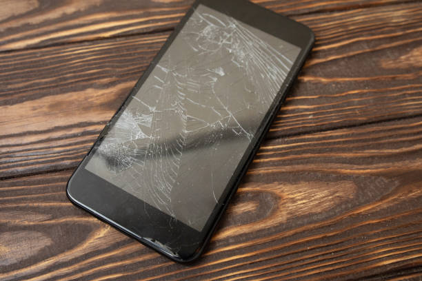 istock Modern broken mobile phone on old wooden background 1147285997