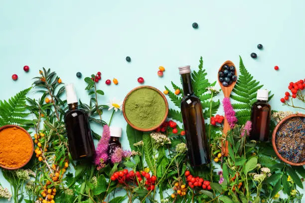 Photo of Healthy super food, berries, turmeric, spirulina, omega acid capsules, vitamin c supplement, medicinal herbs and spices on blue background. Antioxidants concept. Copy space, top view