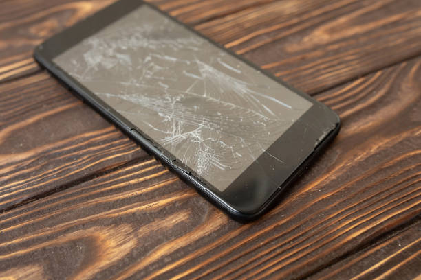 istock Modern broken mobile phone on old wooden background 1147287185