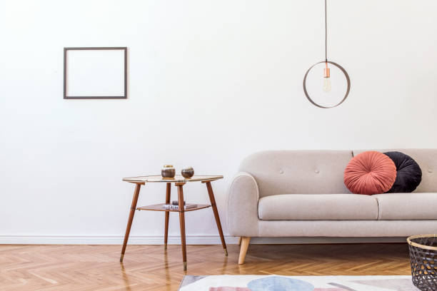 istock Stylish minimalistic living room with design grey sofa, geometric lamp, coffee table, pillows and elegant accessories Mock up posters frame on the white walls. Minimalistic home decor. 1147287741
