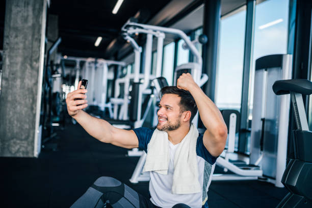 istock Young man showing off his arm muscles, taking selfe in the gym. 1147288083