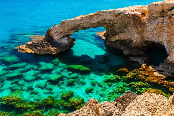 Beautiful natural rock arch near of Ayia Napa, Cavo Greco and Protaras on Cyprus island, Mediterranean Sea. Legendary bridge lovers. Amazing blue green sea and sunny day.